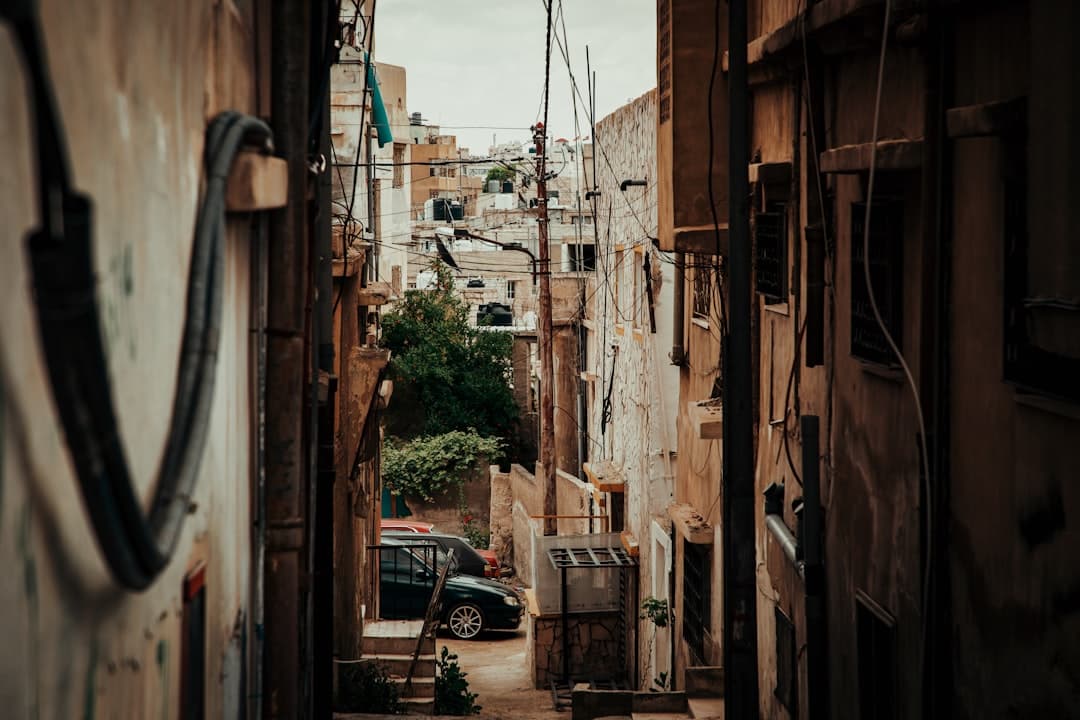 A steep public staircase climbing between houses on an Amman hillside